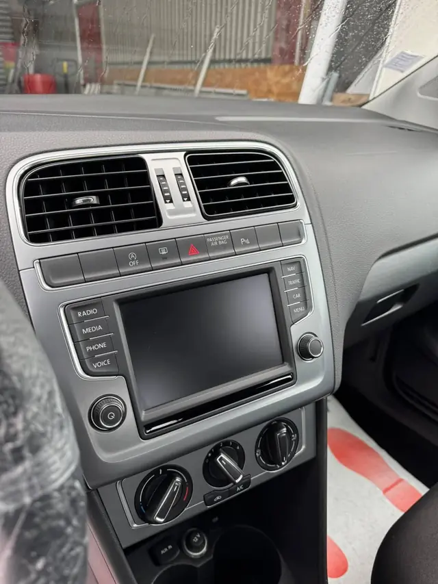 Tableau de bord de la Volkswagen Polo dépoussiéré, écran et commandes de climatisation nettoyés